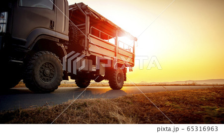 military truck running on asphalt highway against military truck running on asphalt highway against 65316963
