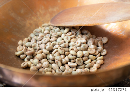Close up of green coffee beans in brass pan 65317271