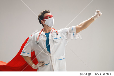 Doctor wearing facemask and superhero cape 65318764
