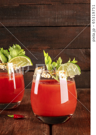Bloody Mary cocktail with tomato juice, lime, and celery, side view on a rustic background 65319751