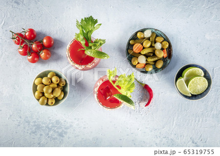 Bloody Mary cocktail with tomato juice, lime and celery, with pickles and olives, shot from above with a place for text Bloody Mary cocktail with tomato juice, lime and celery, with pickles and olives, shot from above with a place for text 65319755