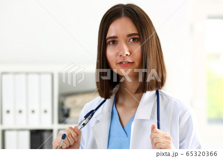 Beautiful smiling female doctor stand in office portrait 65320366