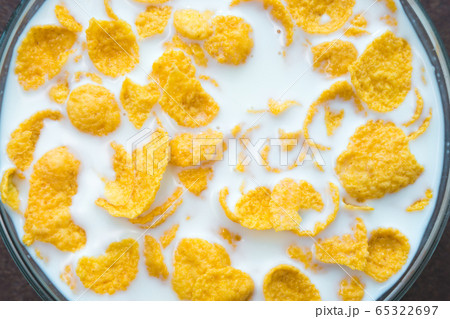 breakfast corn flakes. milk into bowl of corn flakes background, top view. Healthy breakfast. Food and drink industry. breakfast corn flakes. milk into bowl of corn flakes background, top view. Healthy breakfast. Food and drink industry. 65322697