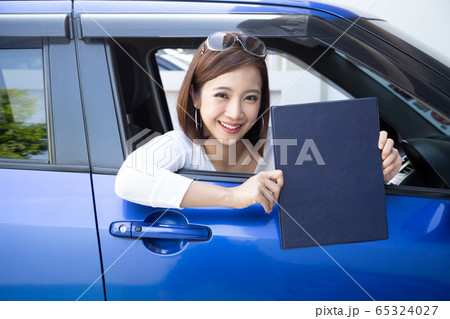 Happy Asian woman holding car insurance document Happy Asian woman holding car insurance document 65324027