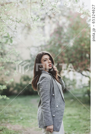 l happy smiling lady posing near flowering tree 65324627