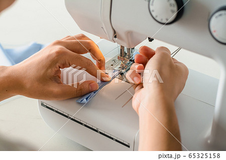 Close up dressmaker is process electric sewing machine with fabric and thread ,starting for tailor business. Close up dressmaker is process electric sewing machine with fabric and thread ,starting for tailor business. 65325158