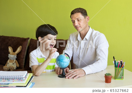 Boy with father doing homework during the coronavirus quarantine. 65327662