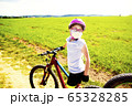 Sport and quarantine. 9 years biker girl in a mask amidst of the fields in the sunny day 65328285