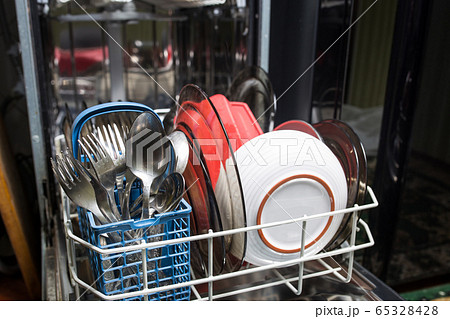 Dishwasher with dirty dishes closeup. Household kitchen appliances. Assistant hostess. Dishwasher with dirty dishes closeup. Household kitchen appliances. Assistant hostess. 65328428