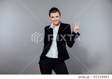 girl showing victory and looking at the camera girl showing victory and looking at the camera 65329963