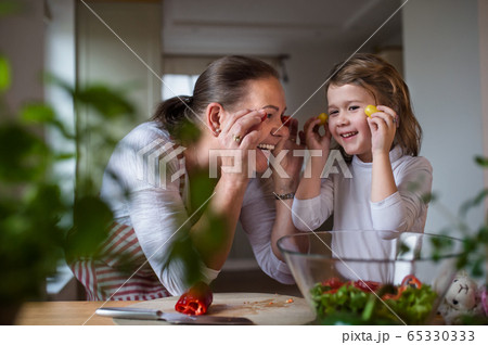 Small girl with senior grandmother in kitchen indoors at home, having fun. Small girl with senior grandmother in kitchen indoors at home, having fun. 65330333