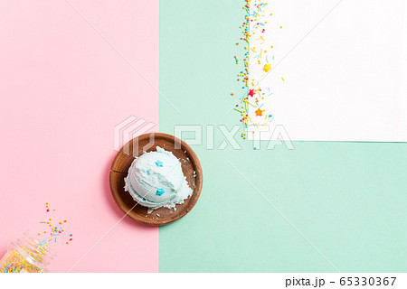 Wooden olive plate with balls of homemade natural ice cream on a tricolor pastel background 65330367