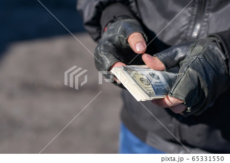 money in the hands of a bandit, a robber who counts the loot money in the hands of a bandit, a robber who counts the loot 65331550