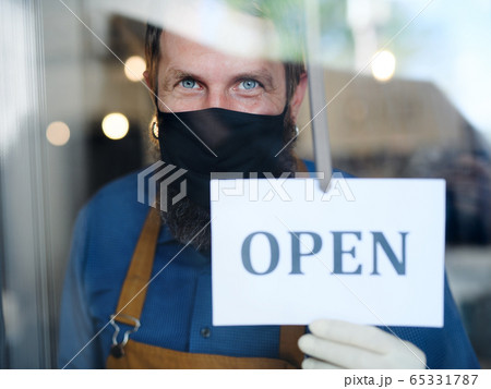 Coffee shop man owner with face mask, open after lockdown quarantine. Coffee shop man owner with face mask, open after lockdown quarantine. 65331787