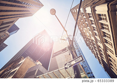 Looking up at New York buildings against the sun. 65333389