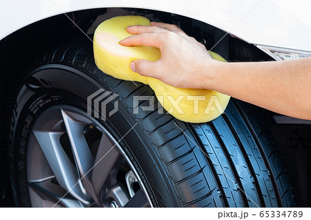 Cleaning car wheel, wiping tire after cleaning on car washing. 65334789