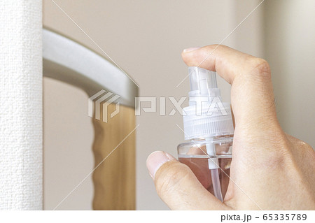 室内の手すりを除菌スプレーで消毒する男性  65335789