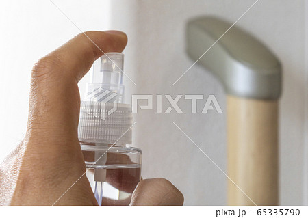 室内の手すりを除菌スプレーで消毒する男性  65335790