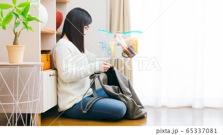荷造りをする女性　トラベルセット　旅行　入院　出張　コピースペース　16:9　 65337081
