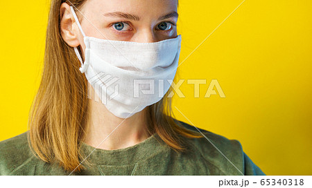 Woman in a gauze mask on yellow background 65340318