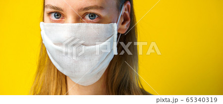 Woman in a gauze mask on yellow background 65340319