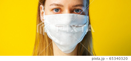 Woman in a gauze mask on yellow background 65340320