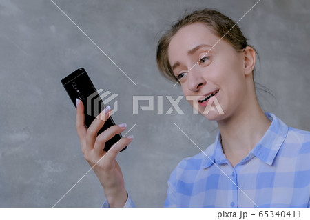 Woman using smartphone, having video chat, interview or consultation 65340411