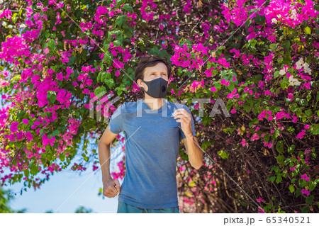 Man runner wearing medical mask. Running in the park. Coronavirus pandemic Covid-19. Sport, Active 65340521