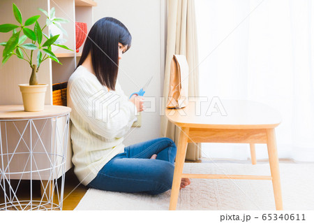 荷物を開封すべきか悩む女性 コピースペース 荷物を開封すべきか悩む女性 コピースペース 65340611