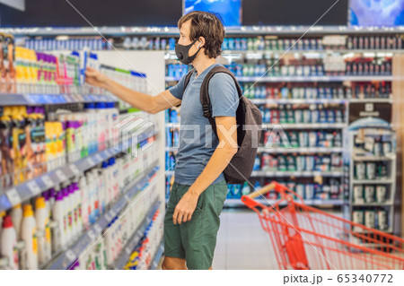 Alarmed man wears medical mask against coronavirus while purchase of household chemicals in Alarmed man wears medical mask against coronavirus while purchase of household chemicals in 65340772