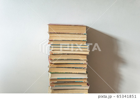 Big stack of old books over white wall Big stack of old books over white wall 65341851