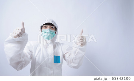 Wide angle images of Asian woman doctor in PPE suit or personal protection equipment and medical goggles, mask, gloves and showing thumb up or like it symbolic which represent happy moment  65342100