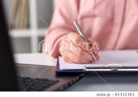 Closeup, female hands taking notes with pen office 65342363