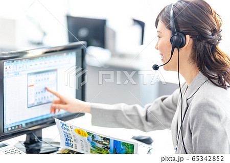 インカムの女性オペレーター　（留学パンフレットは撮影のために作成されたダミーです。） 65342852