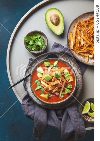 Mexican style table with spicy aztec soup with fried tortilla. Sopa azteca 65344109