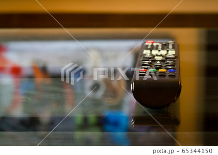 TV television remote on the glass table, ready for watching film or serial TV television remote on the glass table, ready for watching film or serial 65344150