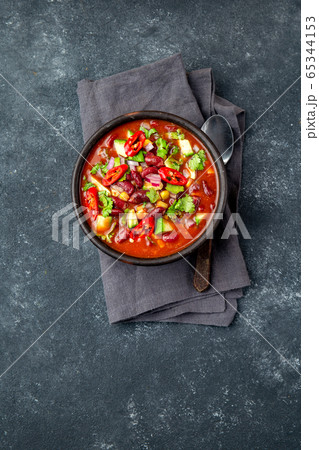 Mexican black bean tomato soup in clay bowl. Gray background 65344153