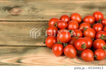 Fresh red cherry tomatoes on a wooden table. 65344813