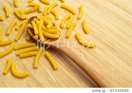 Raw fresh and healthy macaroni pasta on wooden 65350989