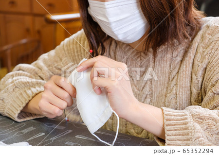 子供用マスクに紐を通す女性　手作り　感染症対策 65352294