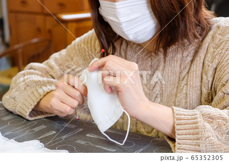 子供用マスクに紐を通す女性　手作り　感染症対策 65352305