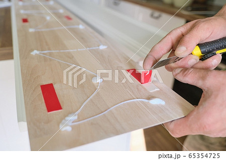 Carpenter male using construction glue when working with wooden white painted board, closeup, carpentry, woodwork, profession, people 65354725