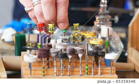 close-Up of the jeweler's hand selects the nozzle for polishing the jewelry. Close-up of jewelry polishing tips. close-Up of the jeweler's hand selects the nozzle for polishing the jewelry. Close-up of jewelry polishing tips. 65359346