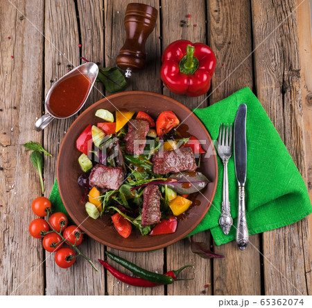 Veal salad with vegetables. Salad on a white plate. 65362074