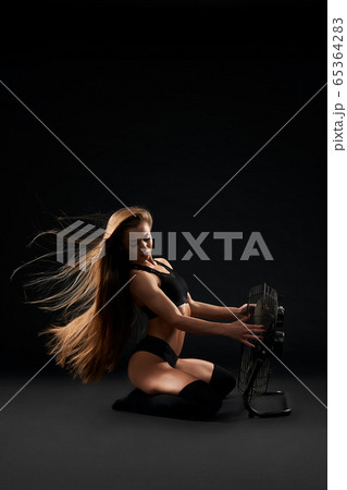 Model posing on floor with fen. 65364283