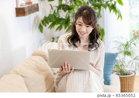 女性　ノートパソコン　自宅　リビングルーム 65365052