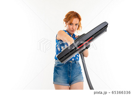 housewife cleans the room with a vacuum cleaner on a white background housewife cleans the room with a vacuum cleaner on a white background 65366336