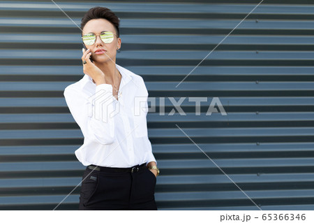 Female in office suit made an appointment and call the phone outside 65366346