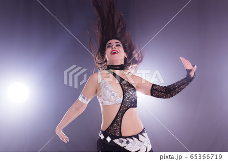 Young woman dancing in Tribal Fusion style. Belly dance on the stage. 65366719