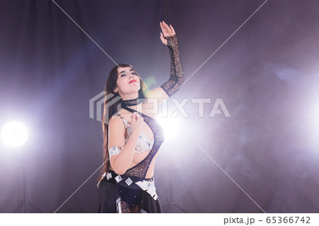 Spirituality dance. Beautiful sexy woman with luxury glossy eastern make-up dancing tribal fusion. Belly dance. Copy space. 65366742